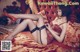 A woman in lingerie and stockings laying on a bed.