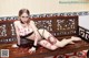 A woman laying on a wooden bench covered in rose petals.