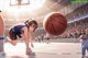 A girl in a blue and black uniform playing basketball.