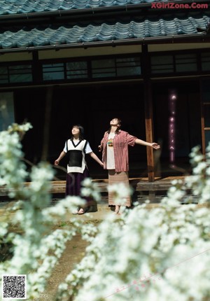 A couple of women standing next to each other in front of a building.