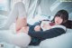 A woman laying on top of a bed with her legs crossed.