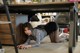 A woman laying on the floor under a desk.