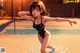 A woman in a black bathing suit standing in a pool.